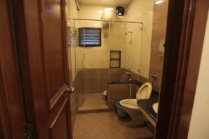 a bathroom with a shower and a toilet and a sink at Hotel Raya's Annexe 1 in Kumbakonam +22 photos
