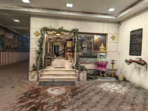 a hallway with stairs and an arch in a building at Hotel Raya's Annexe 1 in Kumbakonam