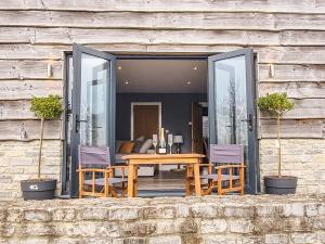 a wooden table and two chairs and a table at The Stables - Uk38514 in Babcary +10 photos