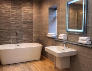 a bathroom with a tub and a sink and a mirror at Lyzzick in Keswick +54 photos