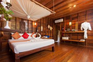
a room with a bed, a table, and a window at Sensi Paradise Beach Resort in Ko Tao
