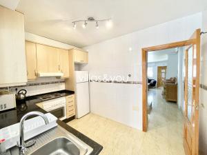 a kitchen with a sink and a stove at Amapolas by Villas&You in Orihuela Costa