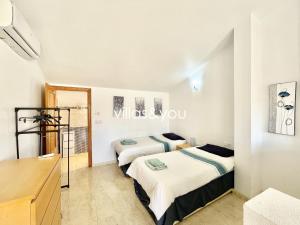 two beds in a room with white walls at Amapolas by Villas&You in Orihuela Costa +22 photos