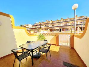 a balcony with a table and chairs and a building at Amapolas by Villas&You in Orihuela Costa