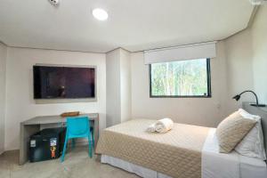 a bedroom with a bed and a desk and a window at Hotel JD in Taquaritinga do Norte
