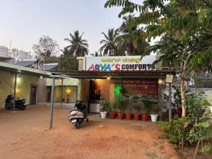 a motorcycle parked in front of a building at Aryas comforts near Gumbaz in Shrīrangapattana