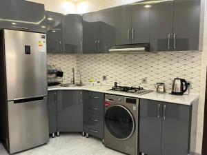 a kitchen with a dishwasher and a washer in it at Ganja VIP Home in Ganja