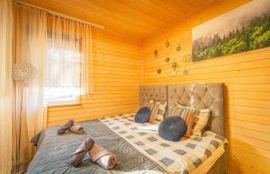 a bedroom with a bed in a wooden room at Lazy Deer - Camp in Staniszów