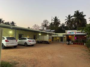 a building with two cars parked in front of it at Aryas comforts near Gumbaz in Shrīrangapattana +11 photos