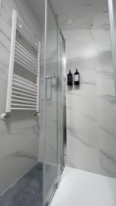 a glass shower in a bathroom with white walls at La Paserina in Arenas de Cabrales +21 photos