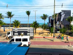 a white van parked on a street with palm trees at Marinas - Flats de Luxo com vista mar in João Pessoa