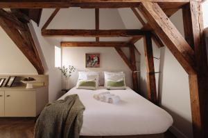 a bedroom with a large white bed with wooden beams at Adam Downtown in Amsterdam