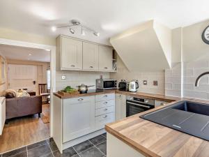 a kitchen with white cabinets and a sink at 1 Bed in Broadway oc-broad in Broadway