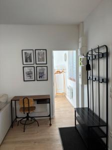 a living room with a table and a chair at Cottage Larris - proche Aéroport - navette Gare in Beauvais
