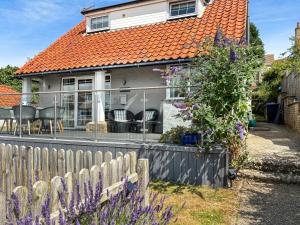 a house with an orange roof and a fence at Beach Haven in Sheringham