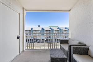 a balcony with a couch and a view of a building at Sugar Beach 313 in Gulf Shores