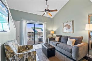 a living room with a couch and a ceiling fan at Sugar Beach 313 in Gulf Shores