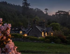 an old house with lights on in a field at Lyzzick in Keswick
