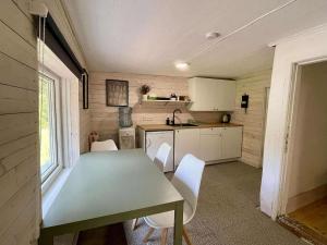 a small kitchen with a green table and white chairs at Peaceful Forest Cabin in Nature in Paluküla