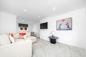 a white living room with a white couch and a table at 3-Bed Home in East Kilbride Ideal for Contractors & Longer Stays from Voyage Collection in East Kilbride