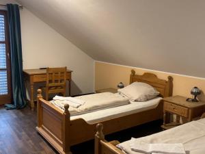a bedroom with two beds and a table and a window at Weissenfelder Guest House & Restaurant in Weißenfeld
