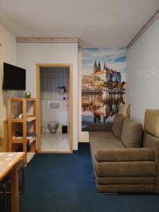 a living room with a couch and a painting on the wall at Gästehaus Schirner in Niederau
