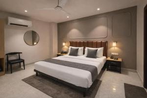 a bedroom with a large bed and a chair at Qotel Comfort Golden Saffron - Hotel in Punjabi Bagh Near Metro in New Delhi