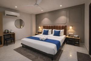a bedroom with a large bed with blue and white sheets at Qotel Comfort Golden Saffron - Hotel in Punjabi Bagh Near Metro in New Delhi