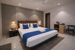 a bedroom with a large bed with blue and white pillows at Qotel Comfort Golden Saffron - Hotel in Punjabi Bagh Near Metro in New Delhi