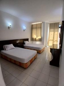 a hotel room with two beds and a window at Regency Hotel Sharm in Sharm El Sheikh +4 photos
