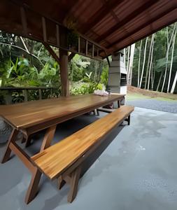a group of wooden benches sitting on a patio at Beautiful View Villa: Sea and Forest in São Francisco do Sul