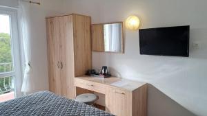 a bedroom with a bed and a tv on a wall at Guest House Villa Bellevue in Cavtat