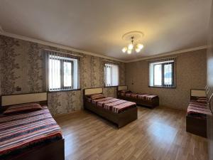 a room with three beds and two windows at Ganja Apartment in Ganja