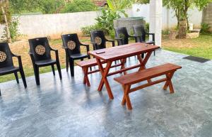 a wooden table and chairs with a bench on a patio at Liya Villa in Ahangama