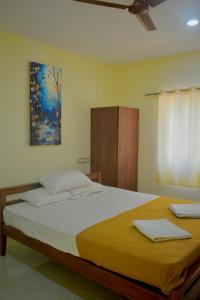 a bedroom with a large bed and a painting on the wall at Gandhada Goodu Retreat in Kanakapura +157 photos