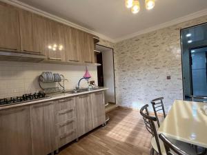 a kitchen with wooden cabinets and a table in it at Ganja Apartment in Ganja +13 photos