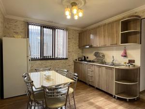 a kitchen with a table and chairs and a refrigerator at Ganja Apartment in Ganja