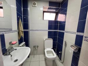 a blue and white bathroom with a toilet and a sink at Ganja Apartment in Ganja