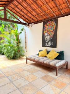 a couch in a patio with a painting on the wall at Rede Andrade Calamarina in Jericoacoara