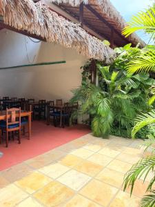 a restaurant with tables and chairs and palm trees at Rede Andrade Calamarina in Jericoacoara +7 photos