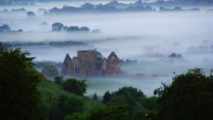 a misty valley with rocks and trees in the foreground at Rockville in Cashel