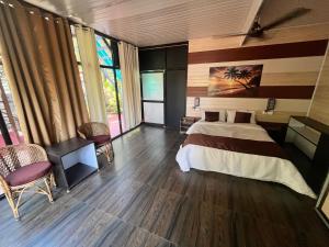 a bedroom with a bed and a table and chairs at Arabian Breeze in Tadri