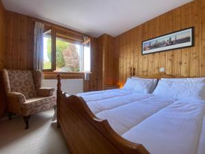 a bedroom with a large bed and a chair at Comfortable 2 bedroom apartment in Gryon in Gryon