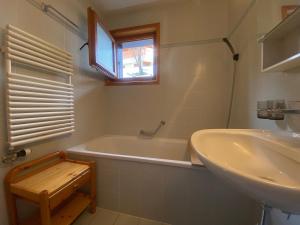 a bathroom with a bath tub and a sink at Comfortable 2 bedroom apartment in Gryon in Gryon