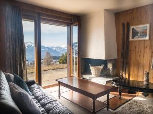 a living room with a couch and a table and a large window at Comfortable 2 bedroom apartment in Gryon in Gryon