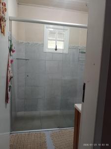 a shower with a glass door in a bathroom at Casa de Alquiler Cláudia in Pântano Grande