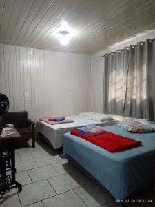a room with two beds and a table and a desk at Casa de Alquiler Cláudia in Pântano Grande
