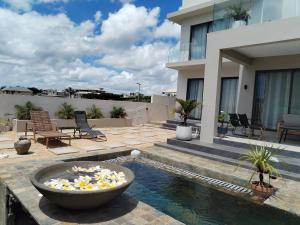 a swimming pool with a bowl in the middle of a house at Fleur&Sel Westcoast Villa in Flic-en-Flac