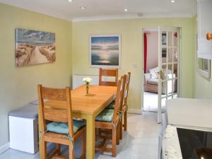 a kitchen and dining room with a wooden table and chairs at Swallowdale in Flordon