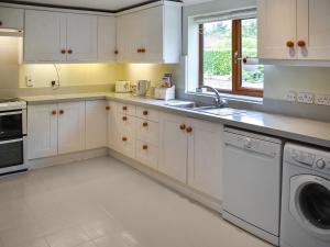 a kitchen with white cabinets and a dishwasher at Swallowdale in Flordon
